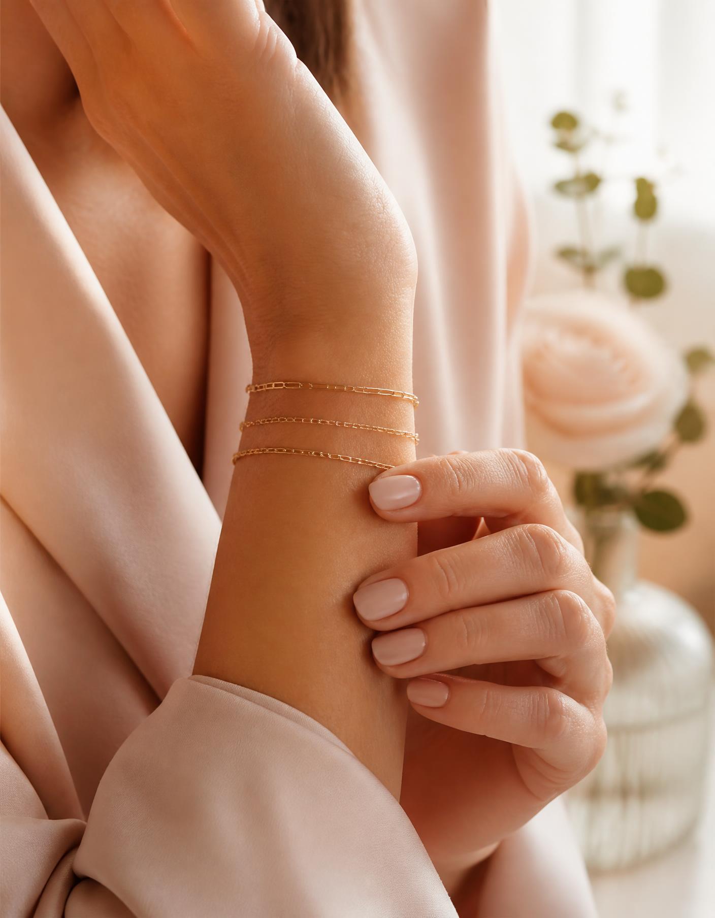 Woman wearing delicate gold permanent bracelets